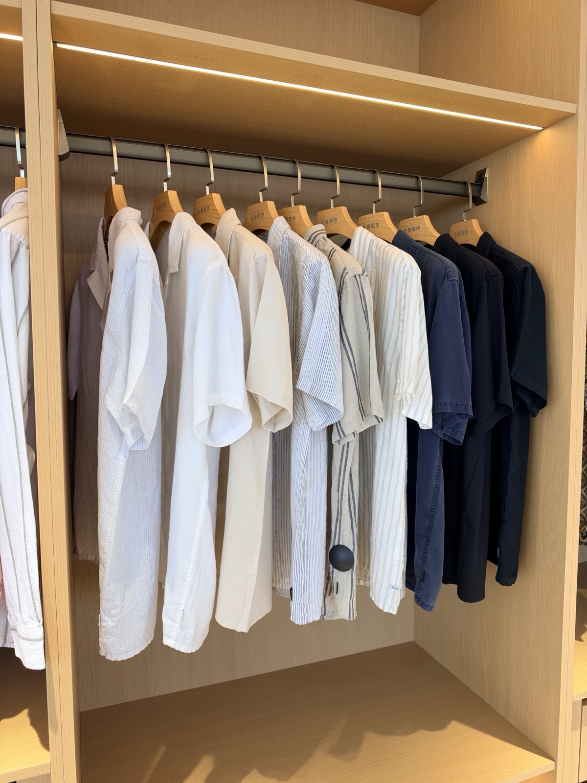 A close view of white, cream, finely striped and navy shirt samples in the showroom
